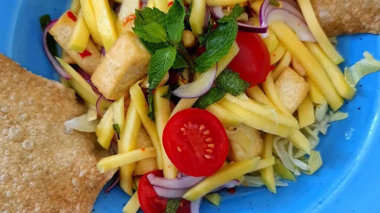 Mango and Tofu salad with tomato, red onion, mint, peanuts and spicy dressing
