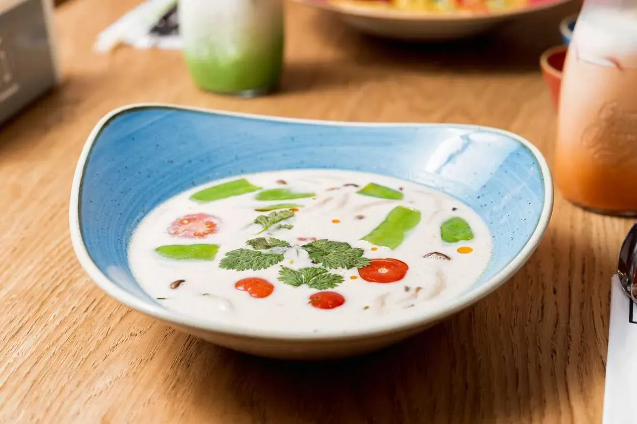 Coconut Milk, Lemongrass and Galangal Soup with Snap Peas, Tomatoes, Champignons, Enoki Mushrooms, Coriander