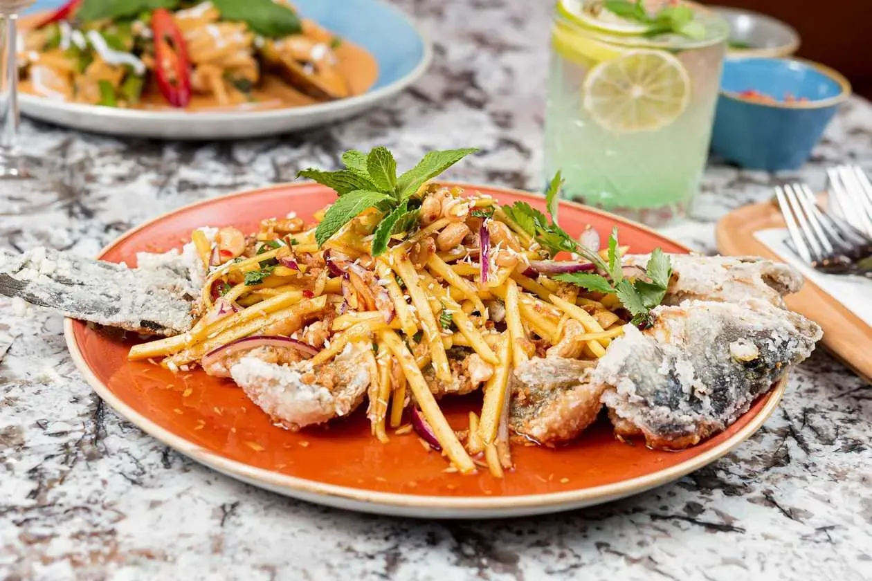 Fried Seabass with Mango, Lemongrass, Coriander, Red Onions, Peanuts, Cashew Nuts and Coconut Shreds