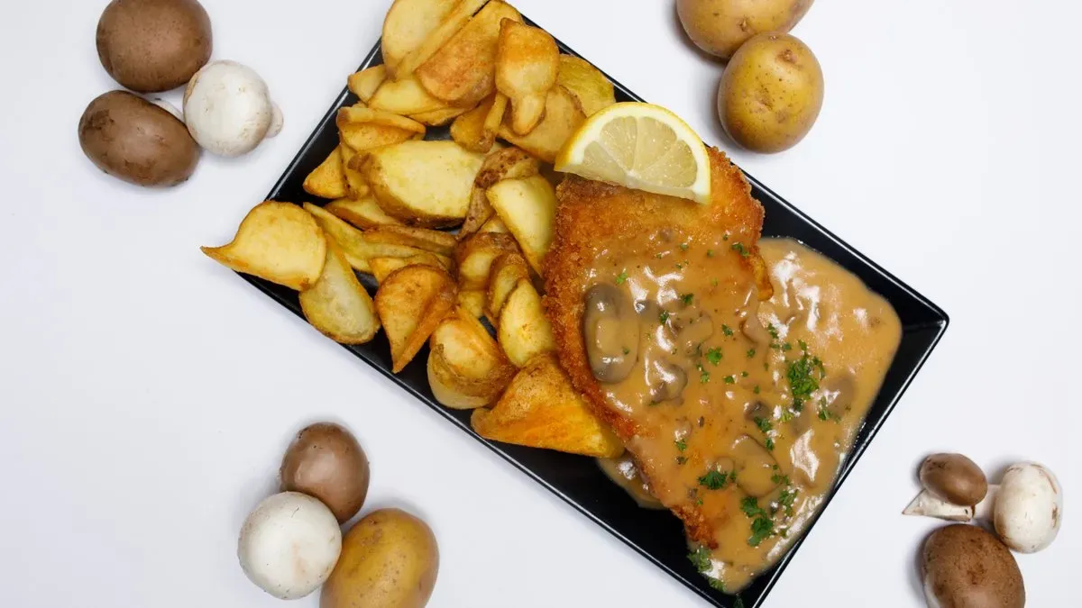 Hähnchenschnitzel Teller mit Pilzrahmsoße und Pommes
