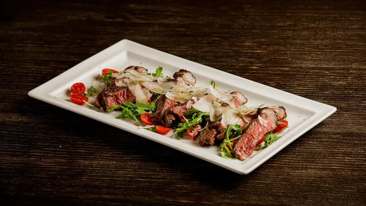 Tagliata di manzo Poznan, rucola e scaglie di Reggiano DOP