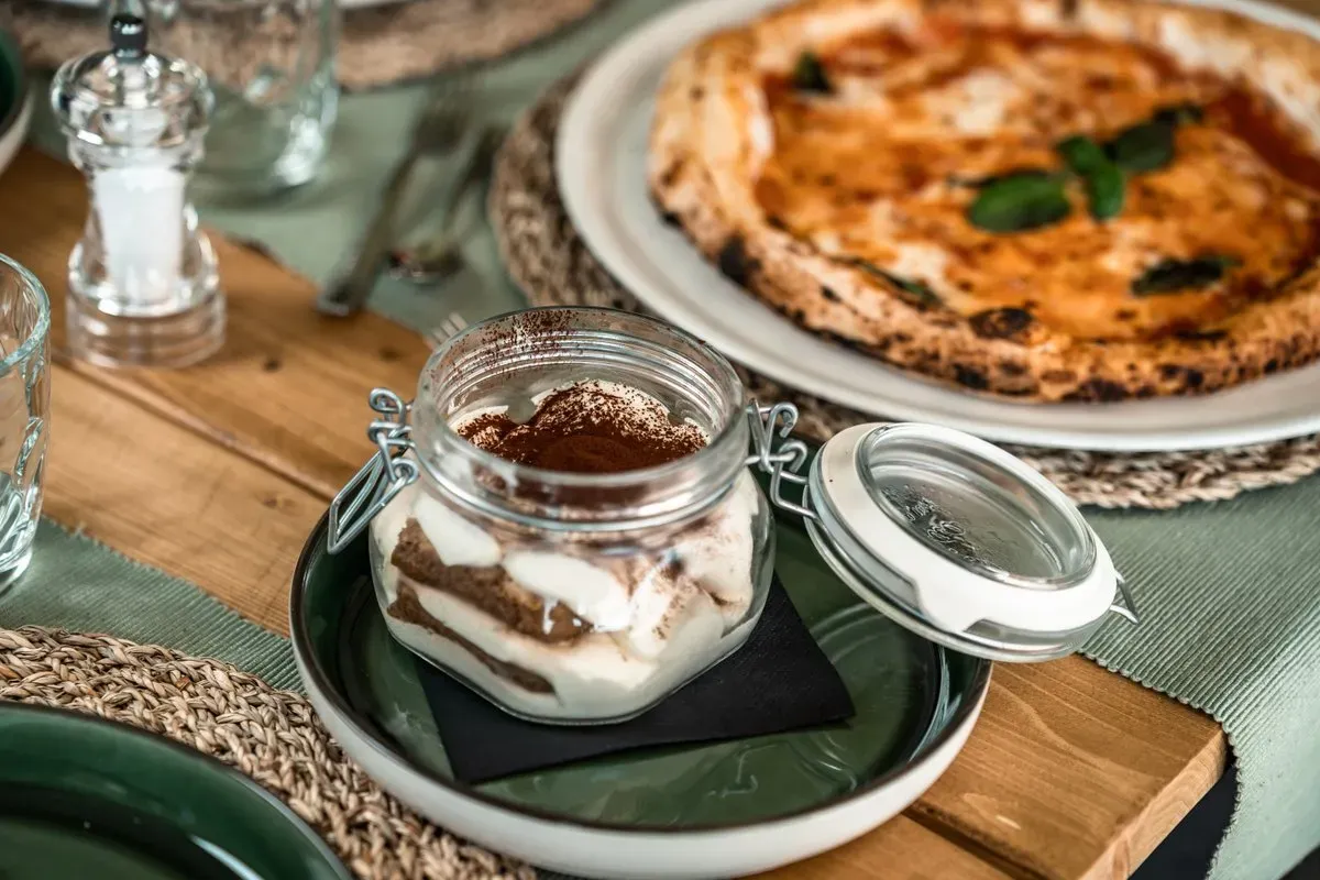 Tiramisu (V) Espresso kávéba áztatott babapiskóta, tiramisu likőrös mascarpone krémmel rétegezve és kakaóporral megszórva