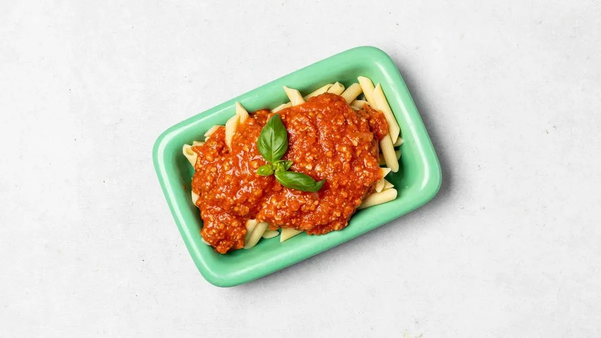Penne w sosie pomidorowym z boczkiem, cebulą i czosnkiem zapiekane serem