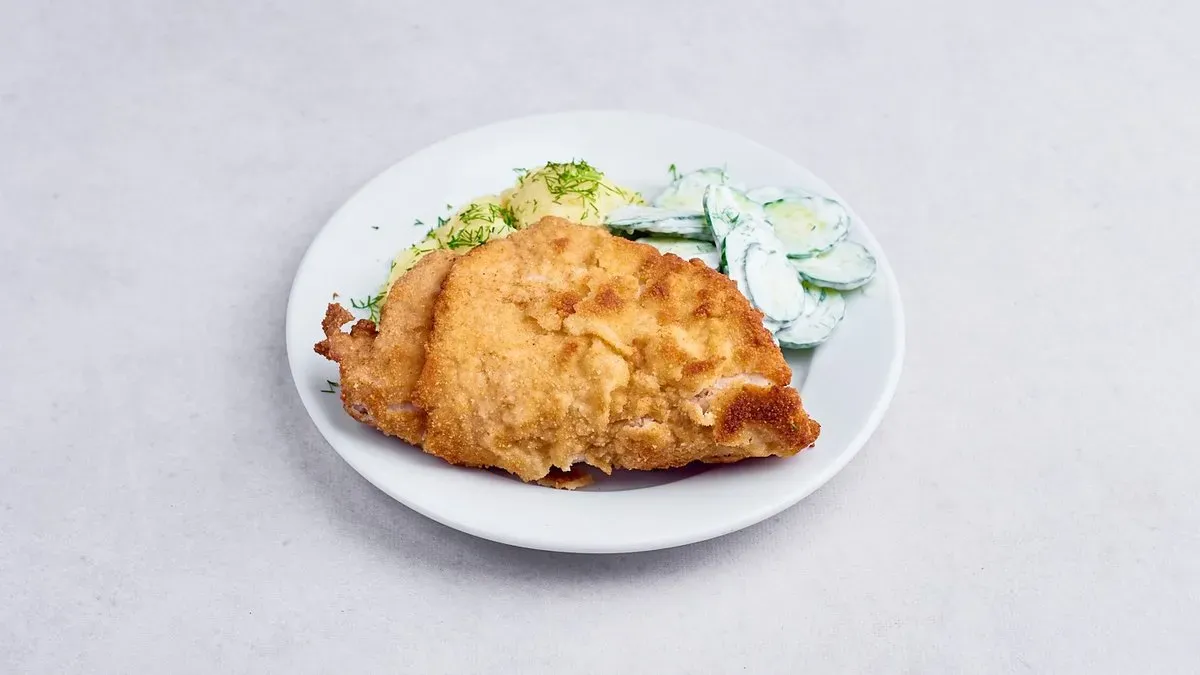 Kotlet schabowy z ziemniakami i mizerią.